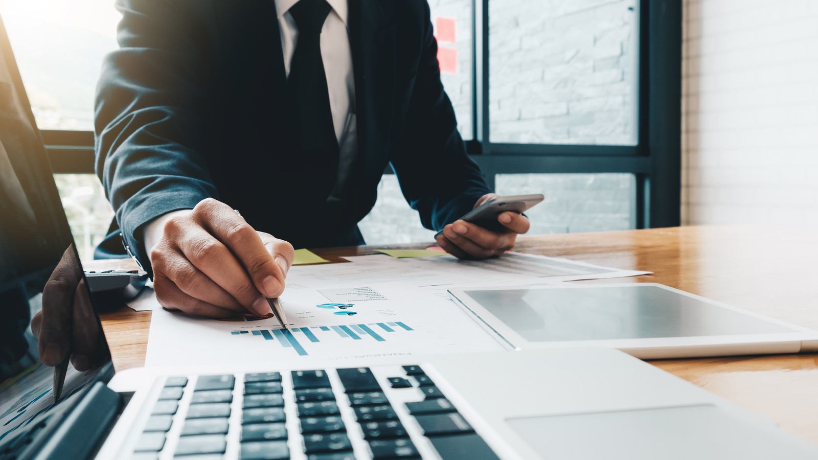 Business man investment consultant analyzing company annual financial report balance sheet statement working with documents graphs. Concept picture of business, market, office, tax.