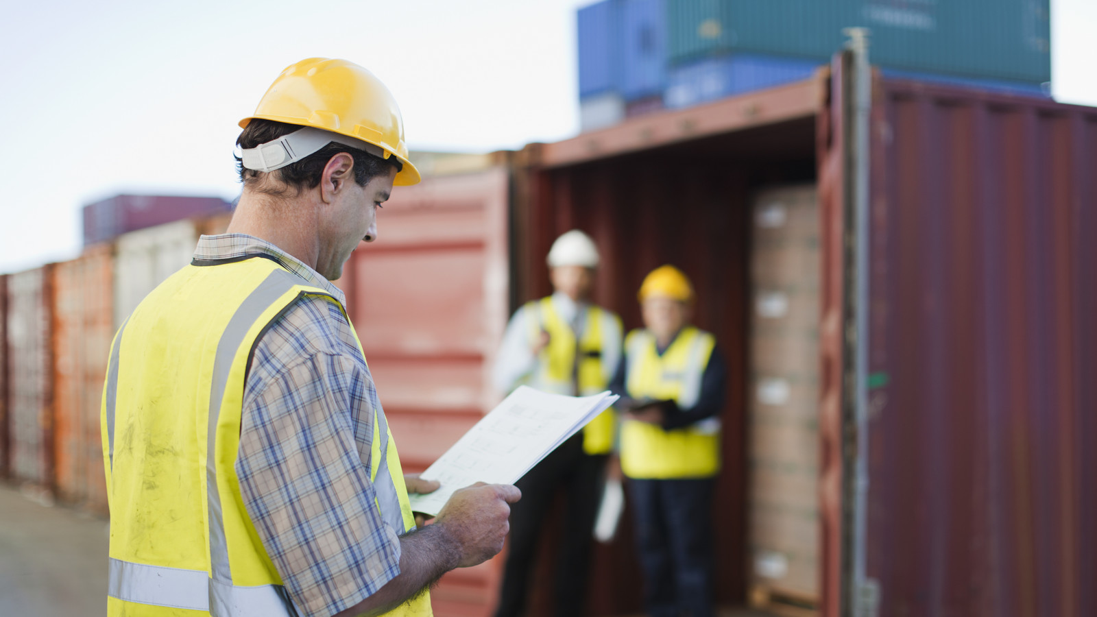 Worker reading in shipping yard