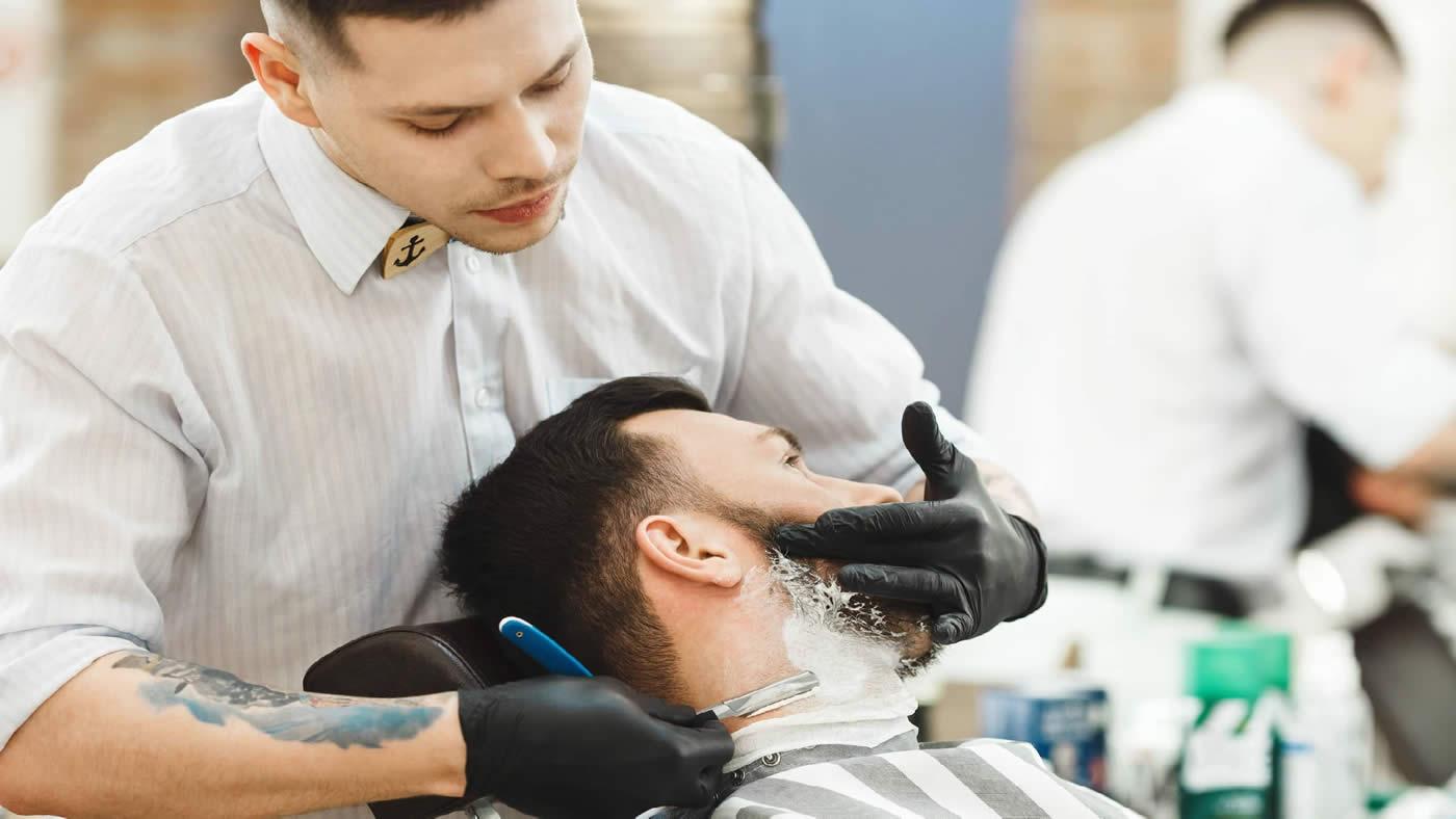 Barber trimming beard
