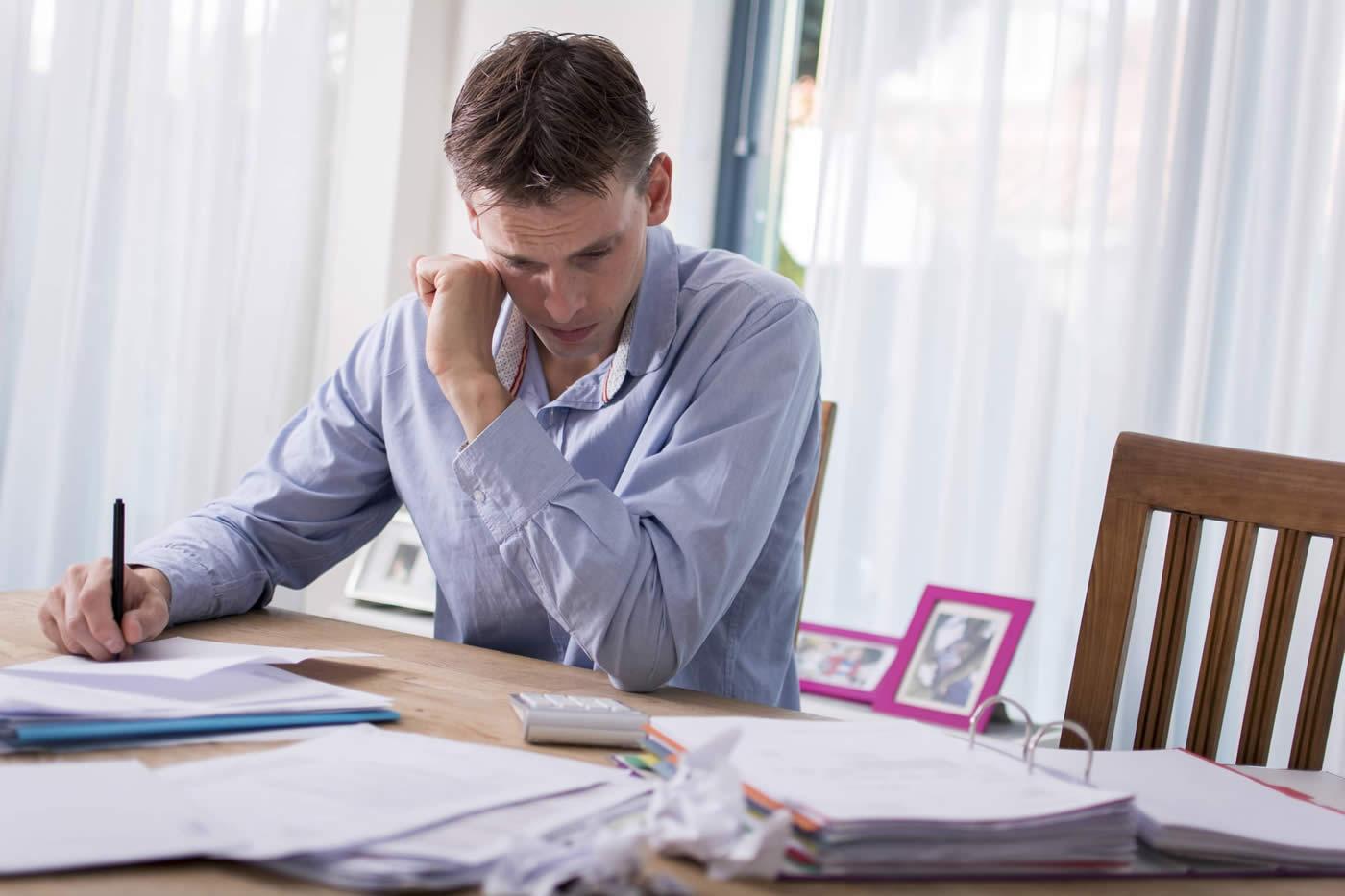Man looking stressed over paperwork
