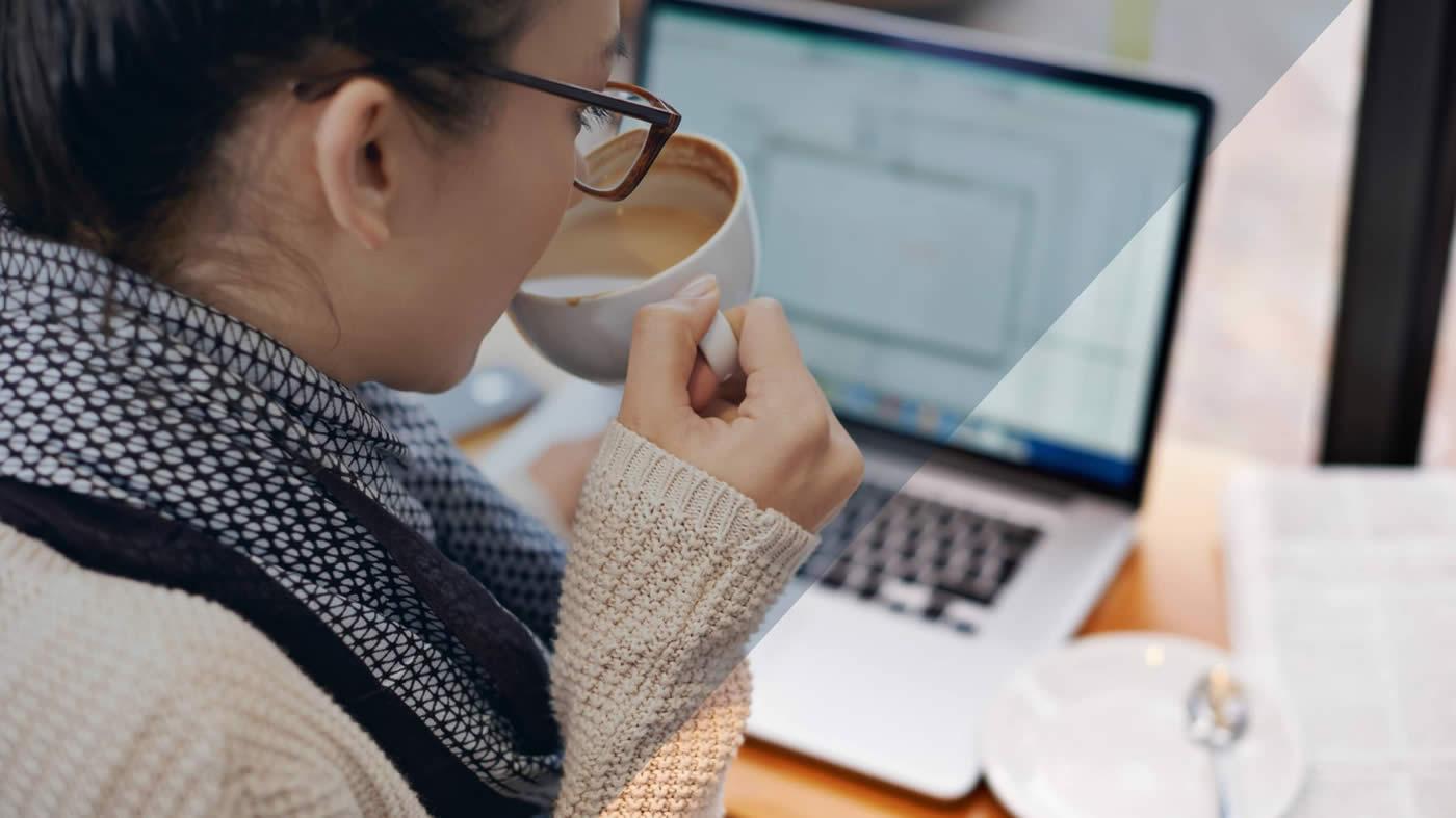Girl supping coffee at desk
