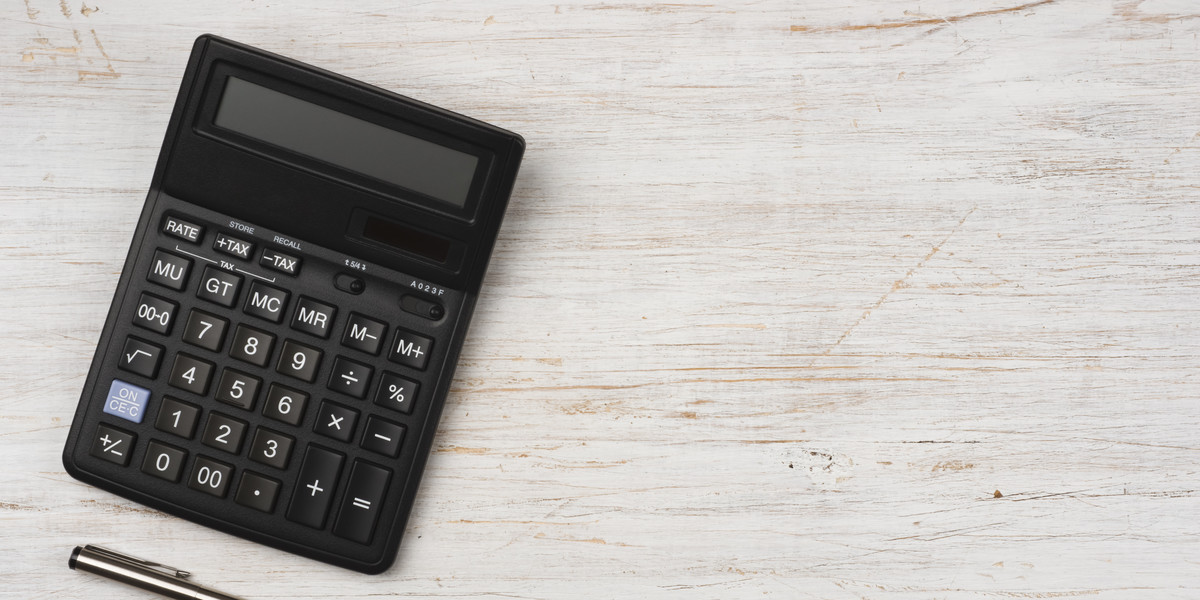 Ink pen and black calculator isolated on wooden texture background
