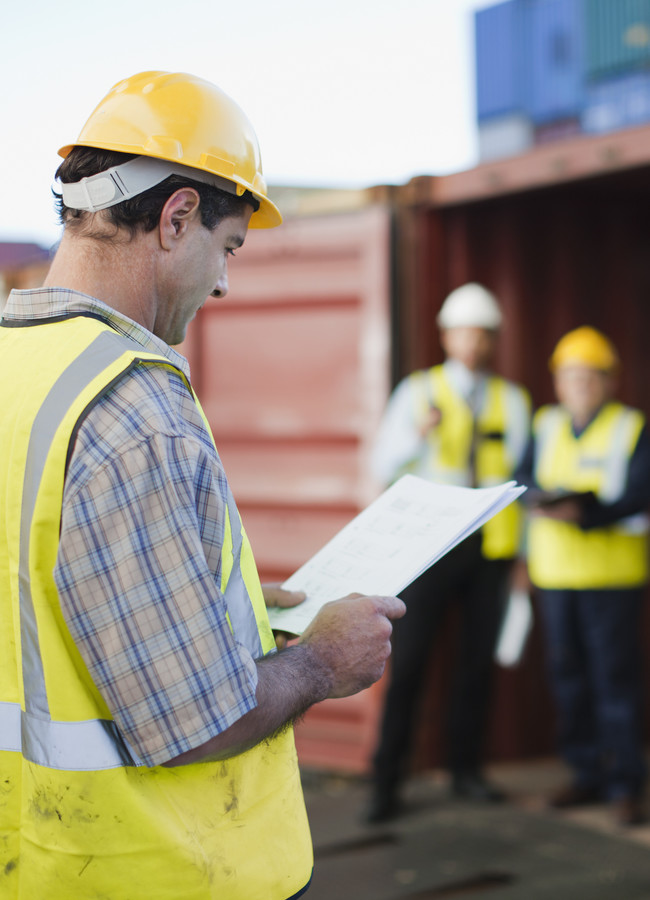 Worker reading in shipping yard