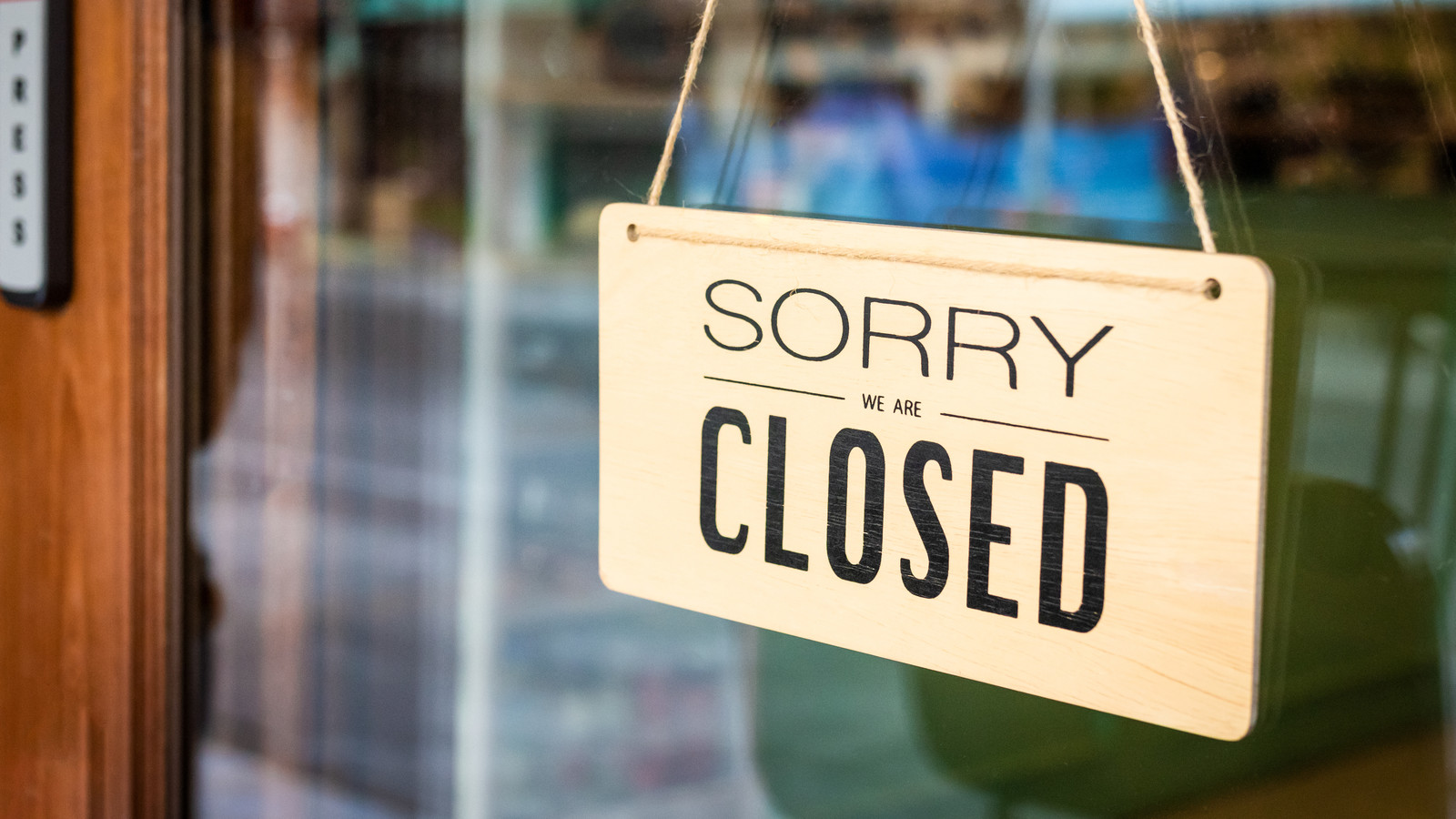 Sorry we are closed sign board hanging on door of cafe