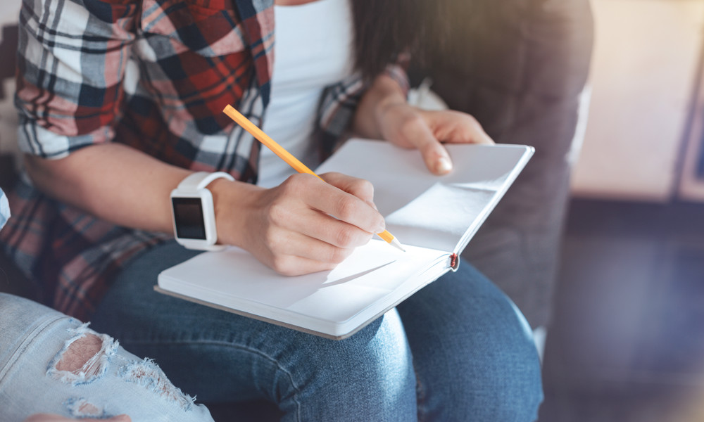 Close up of female hands that holding notebook