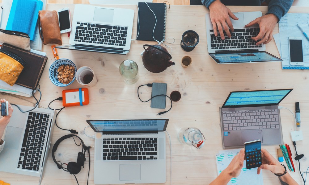 Desk with people working on laptops
